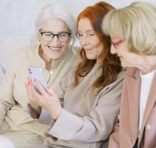 3 senior women engaged in video chatting on a mobile